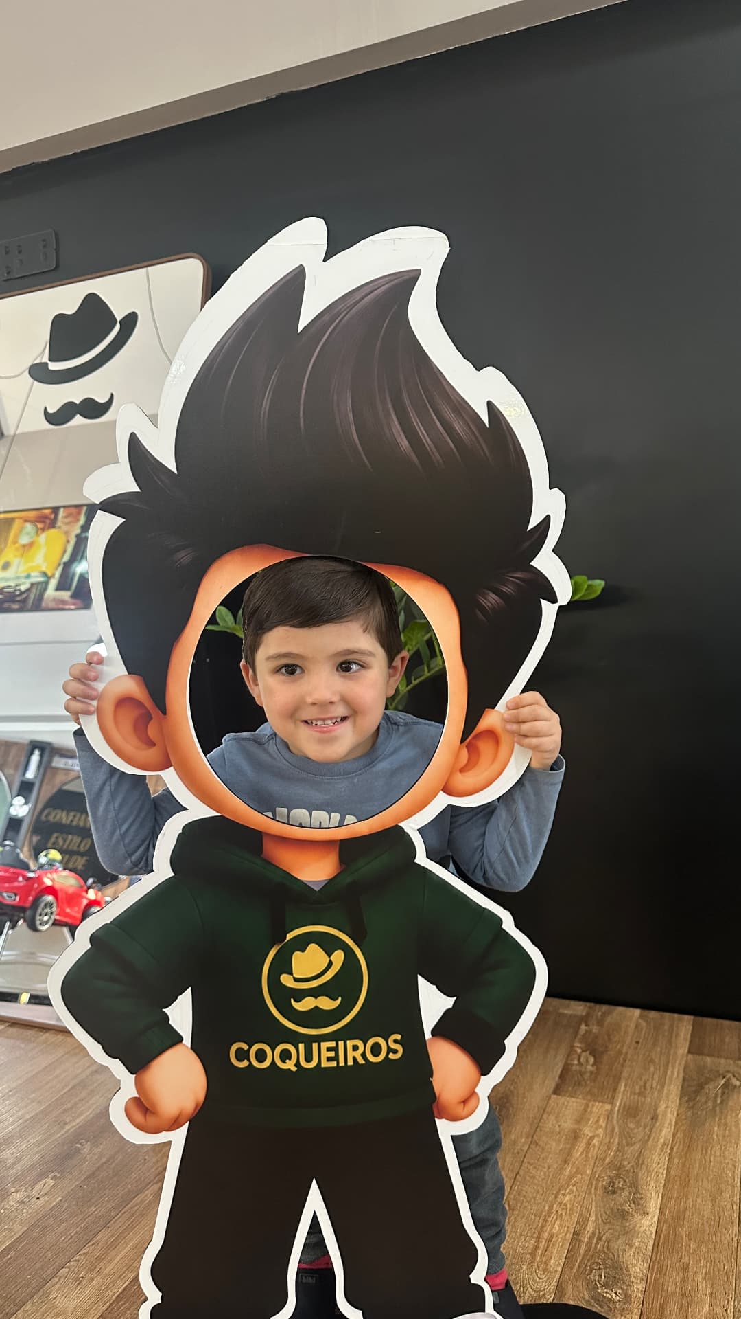 Criança brincando com o boneco da Barbearia VIP Coqueiros