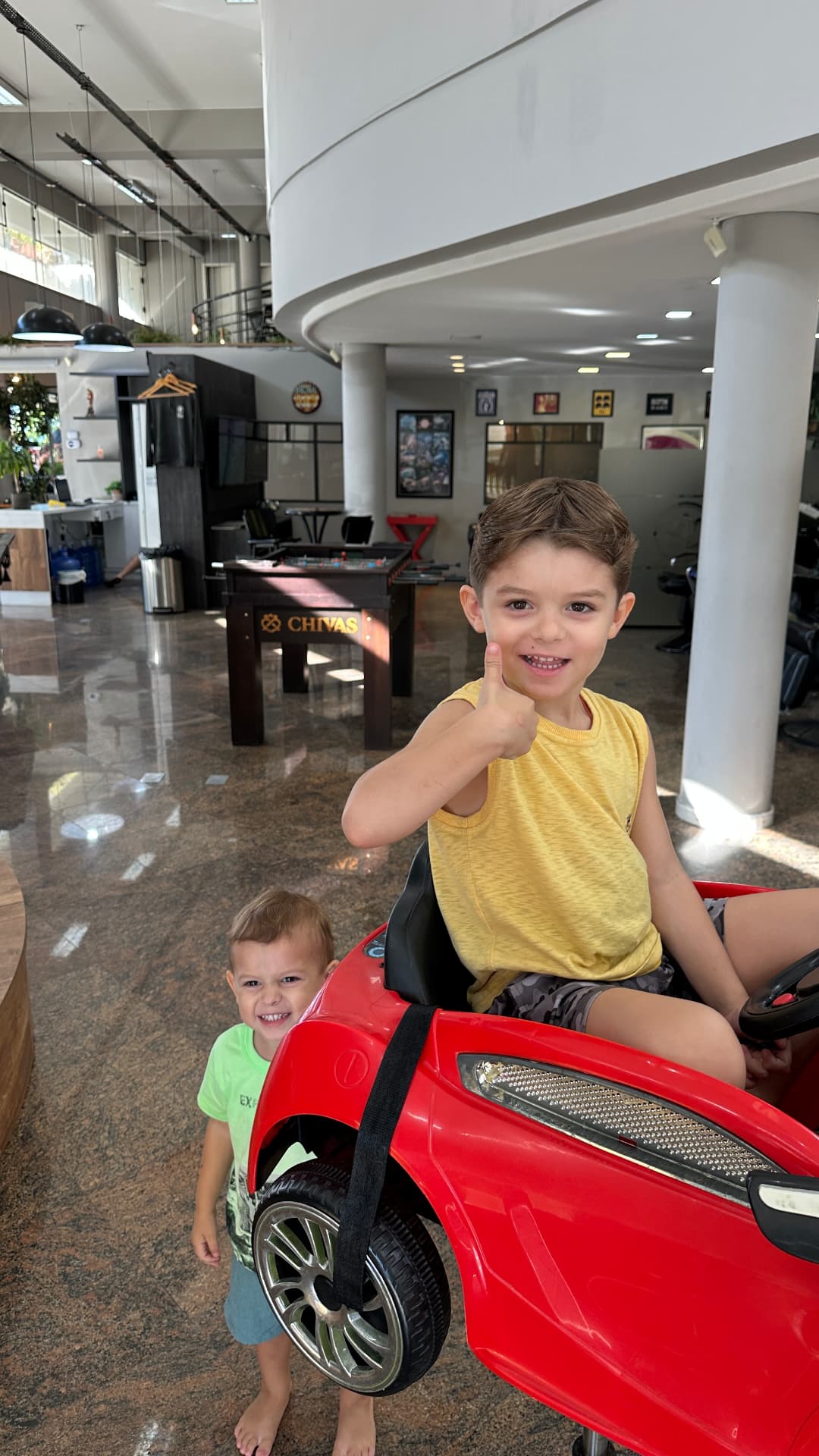 Crianças se divertindo no carrinho vermelho da Barbearia VIP Coqueiros